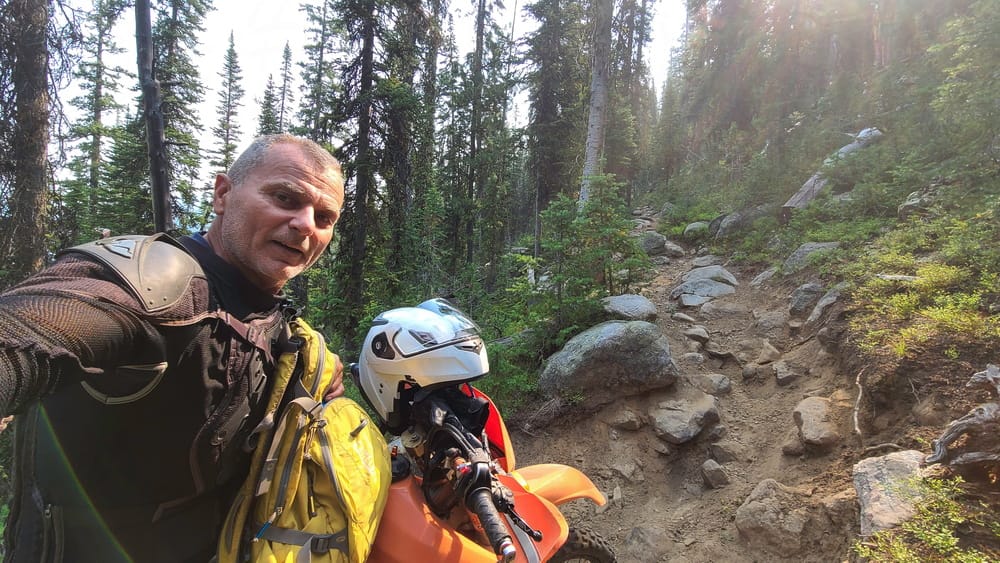 a selfie with otorcycle on a steep, rocky trail