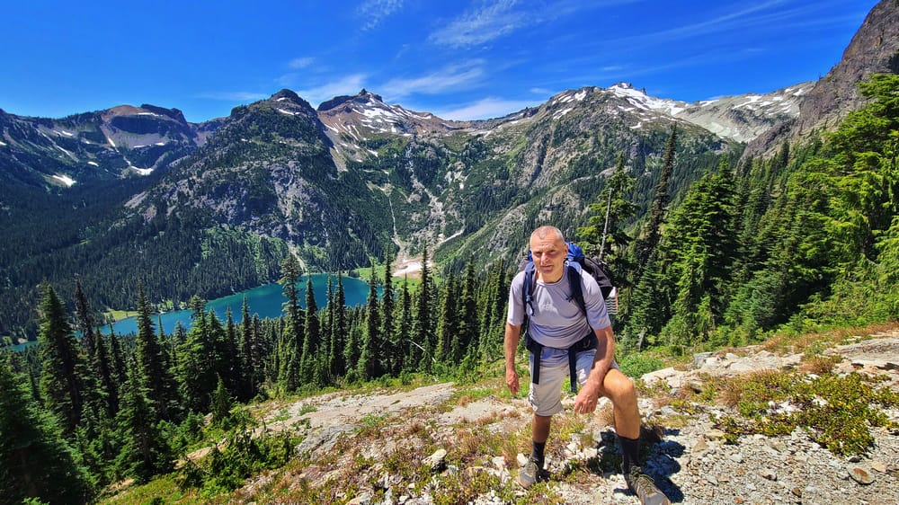 a hiker high above an alpine lake