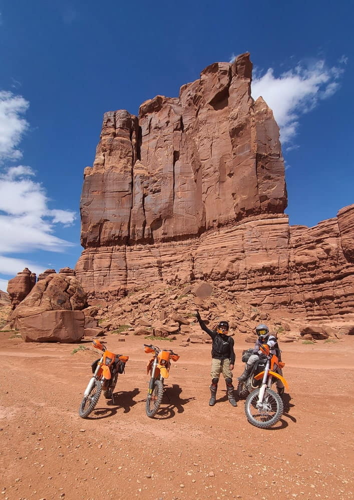 three riders in front of a butte