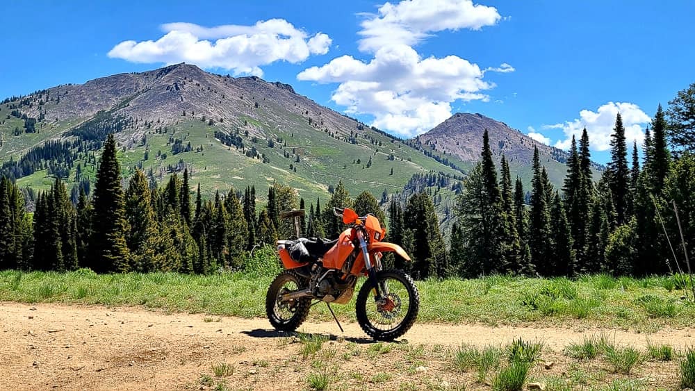 motorcycle parked ona trail with moutain ridge behind