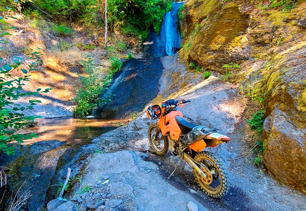 motorycle parked in front of a waterfall