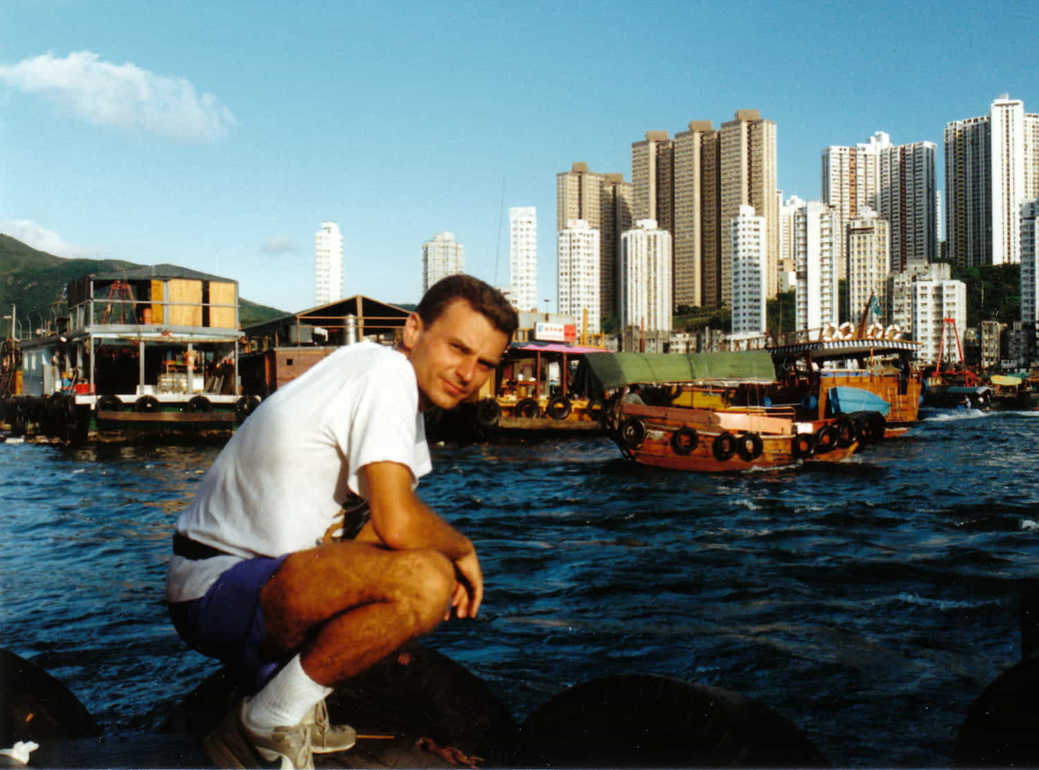 a person in a colorful harbor with city behind