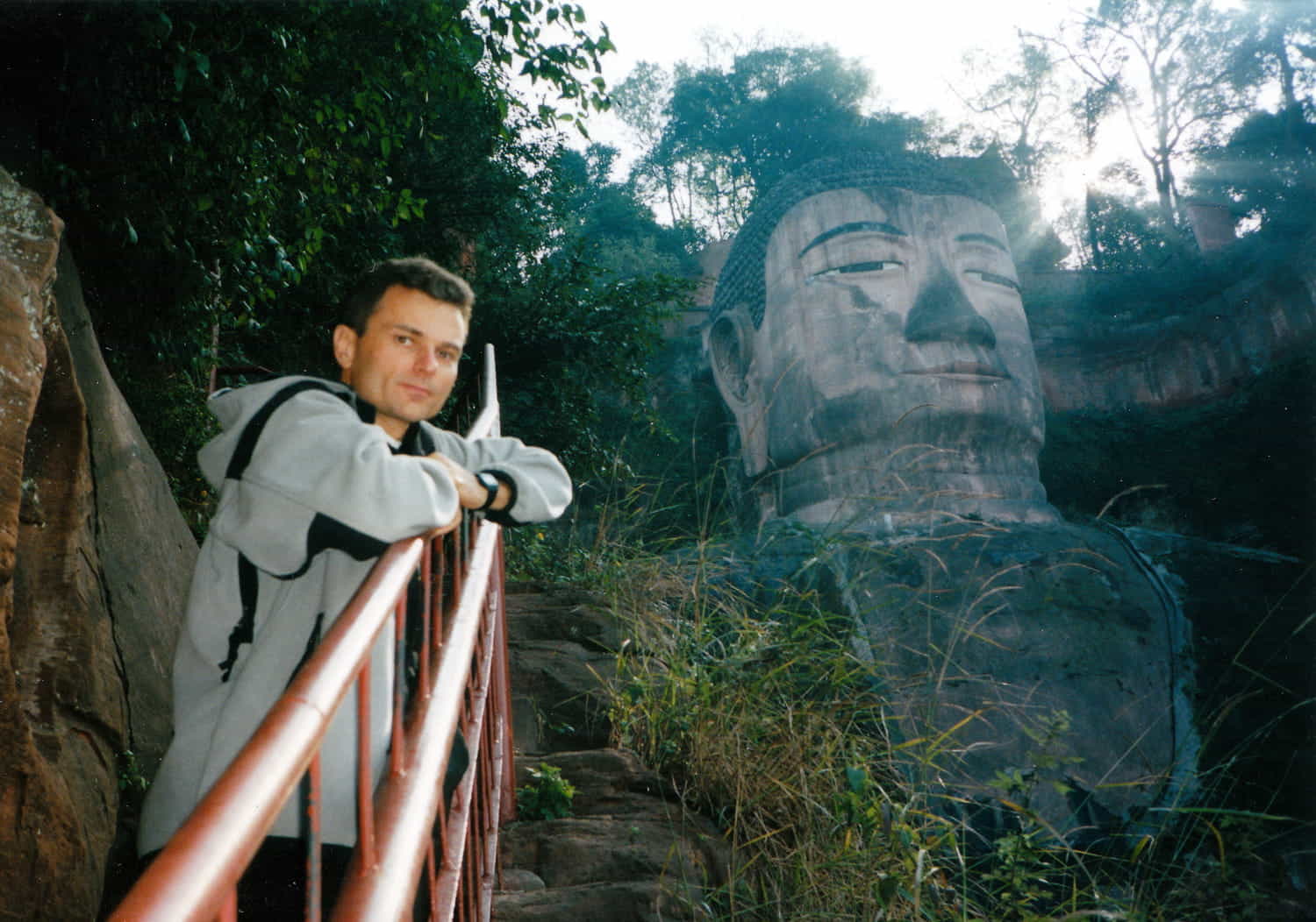 person posing in front of a huge Buddha face