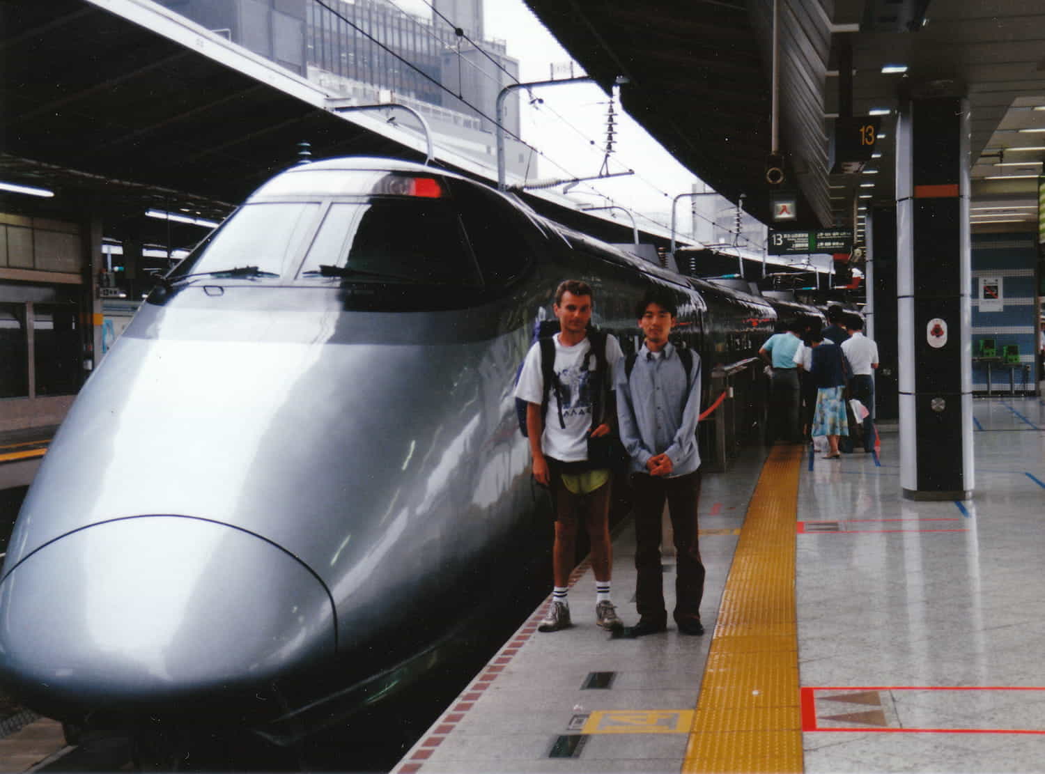 two people next to a bullet train