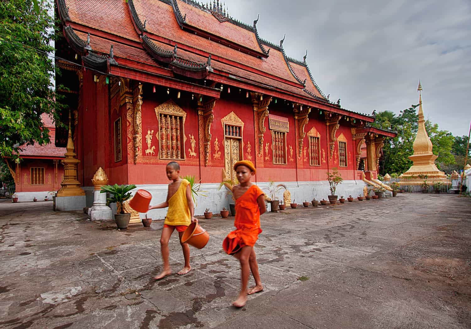 two novice monks in front of a temple