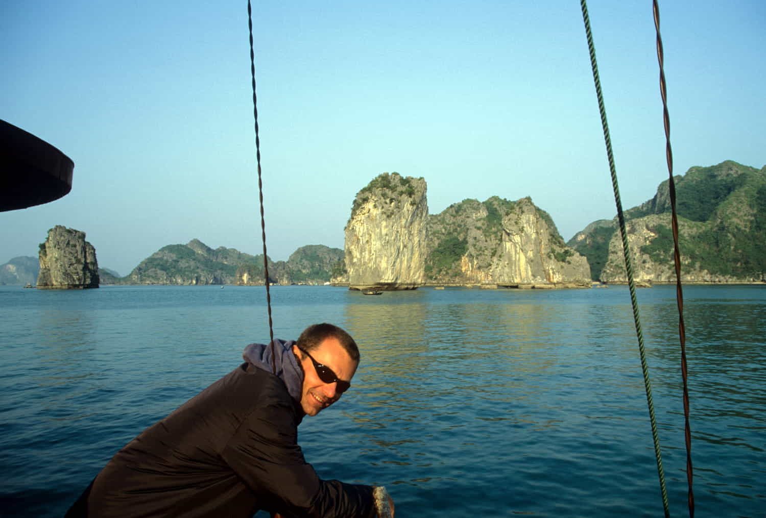  person on a boat with carst islands behind