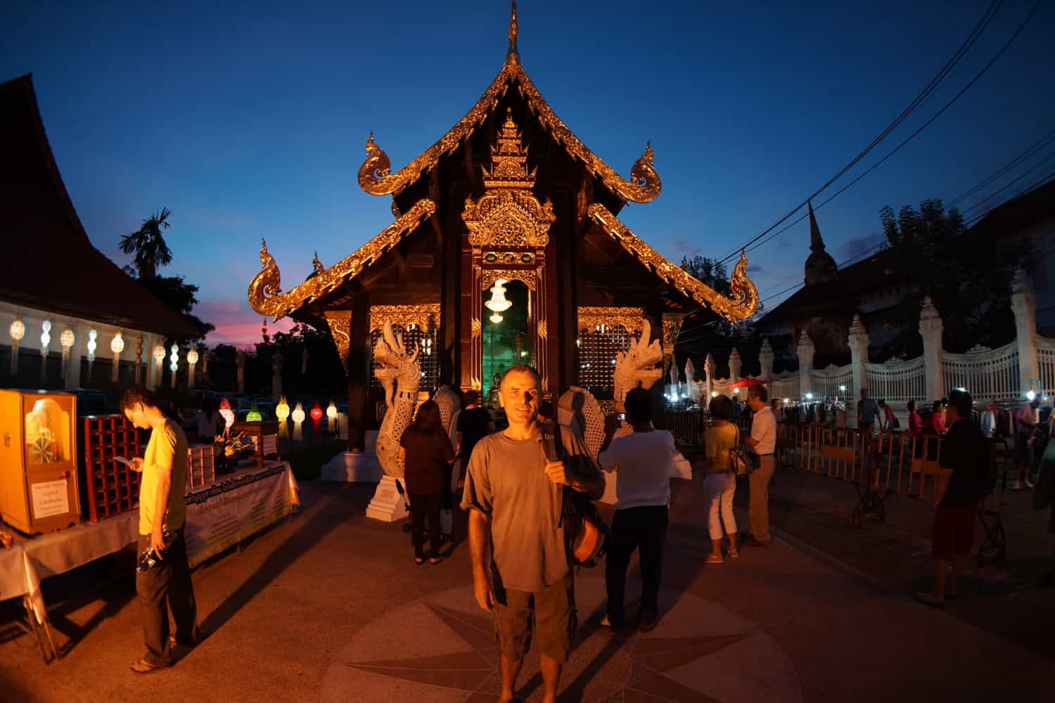 a person in front of a thai temple at dusk