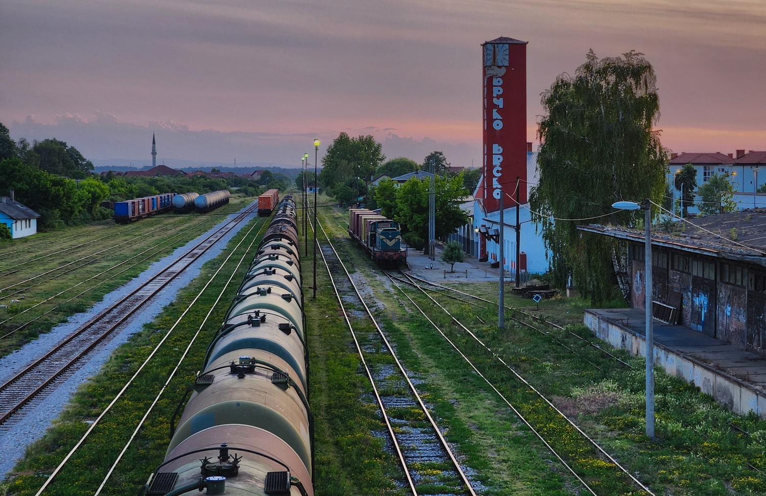 view of a railway station and trains at sunset