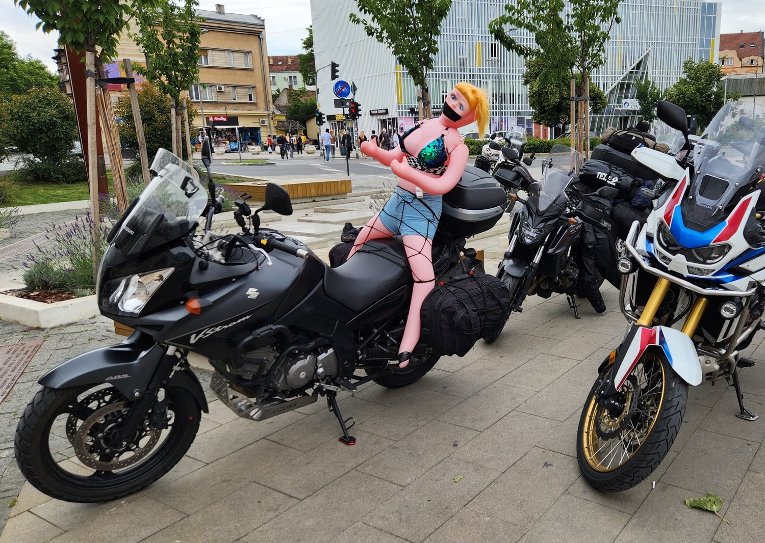 gagged and bound inflatable doll on a motorcycle 