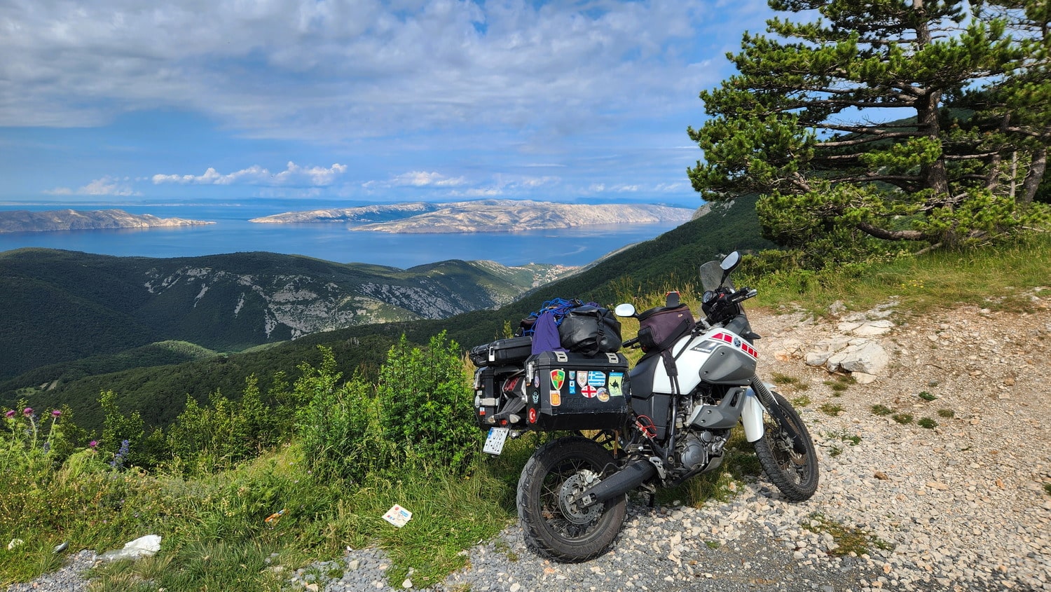 motorcycle parked on a mountain with sea and islands in the distance