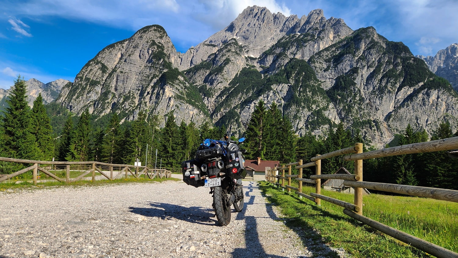 motorcycles on a dirt road with mountains behind