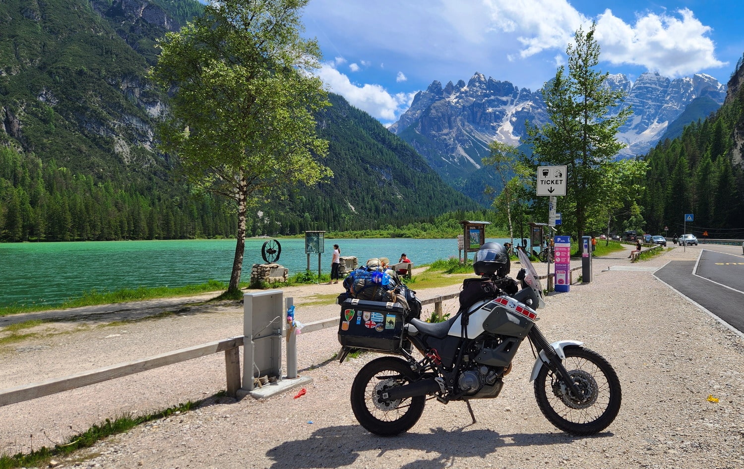 motorcycles next to a lake with mountains behind