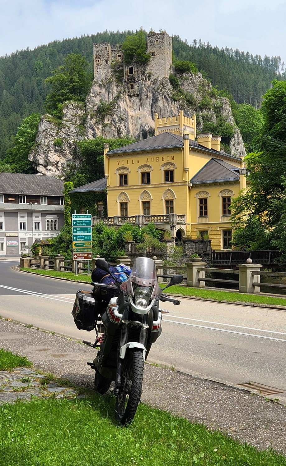 motorcycles on a road with a castle behind