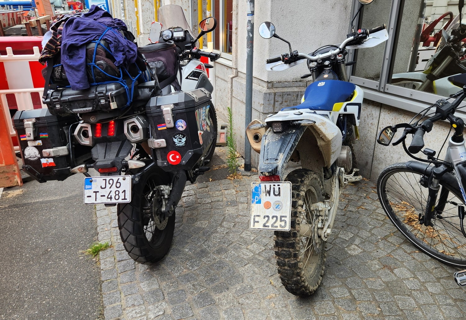 two motorcycles parked on a sidewalk