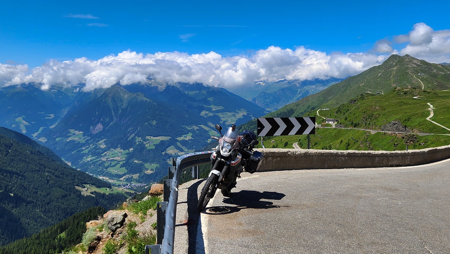  motorcycle parked on a road with a valley deep below