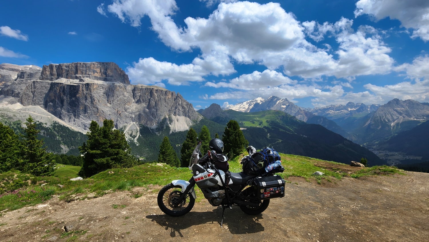 motorcyle parked with deep valley and steep mountains behind