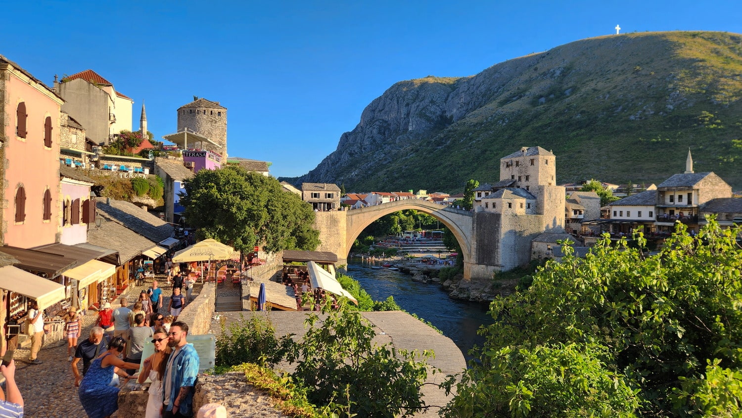 od stone town with a high bridge over a green river