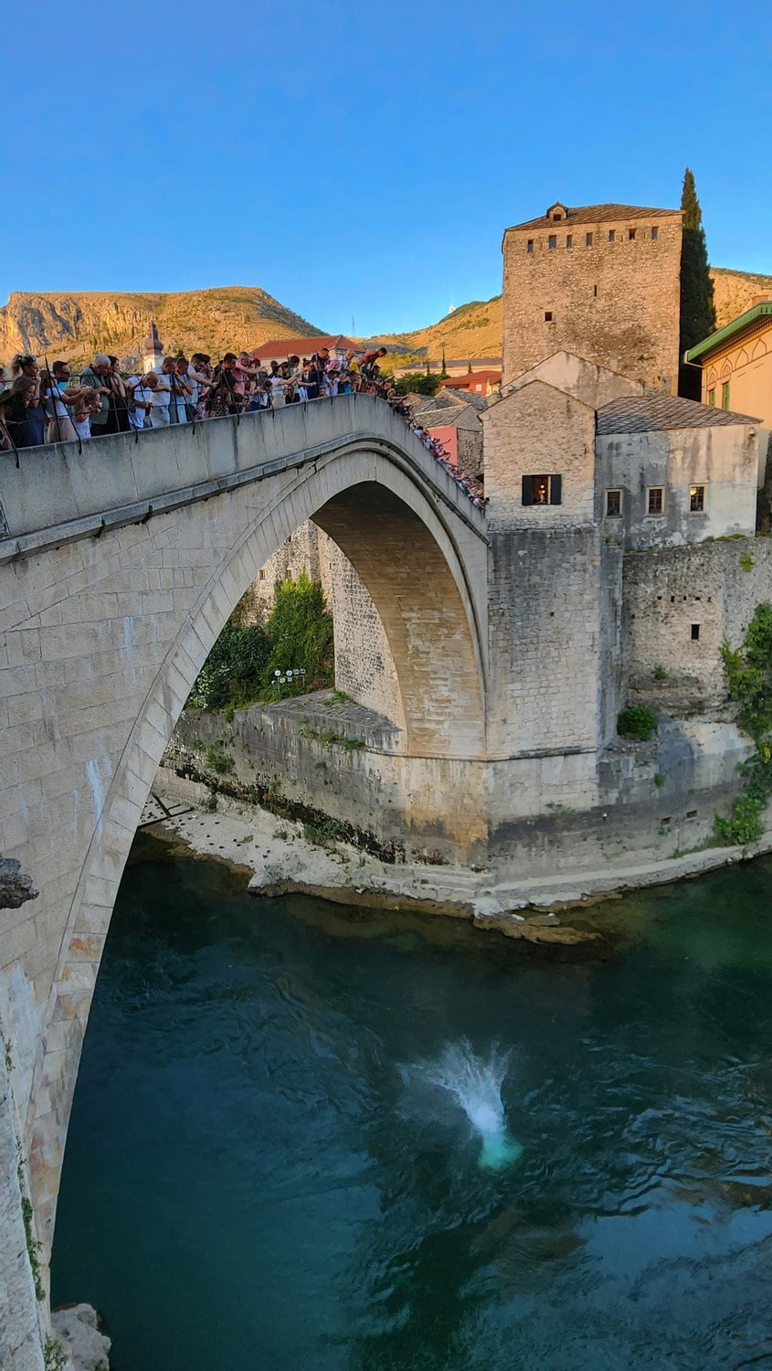 divers jumping off a bridge