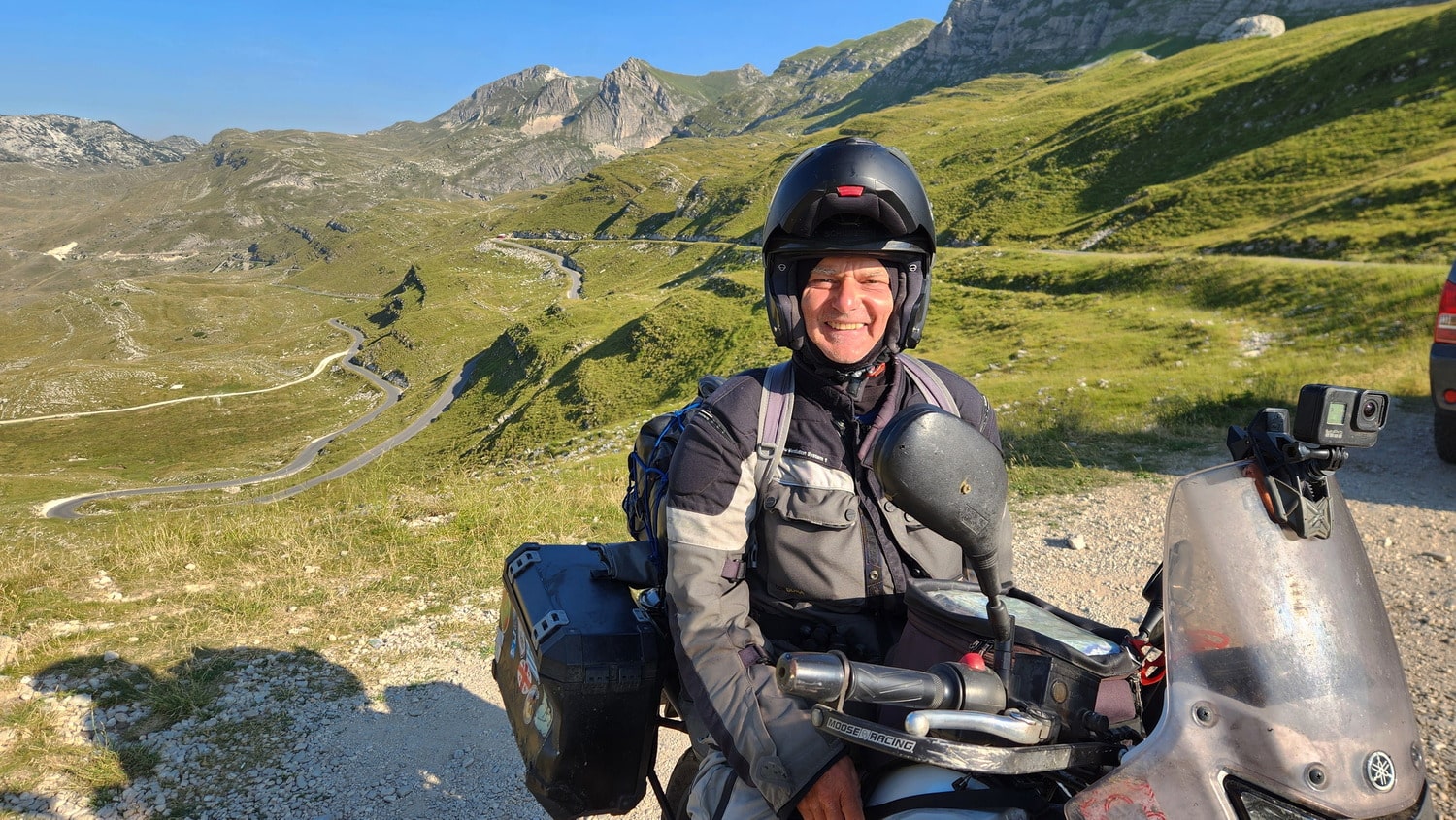 a person on a motorcycle with switchbacks behind