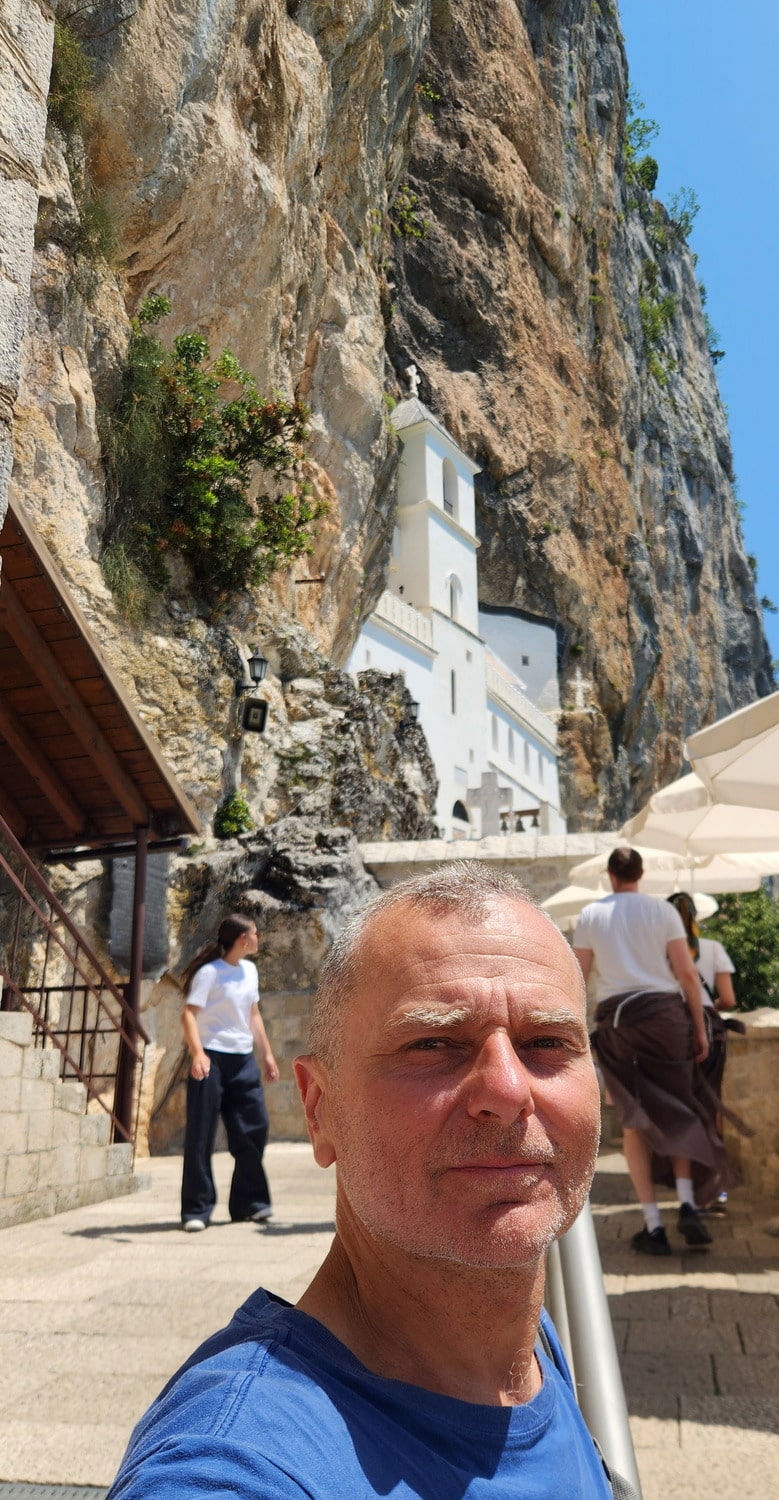 selfie in front of a monastery built into vertical cliffs