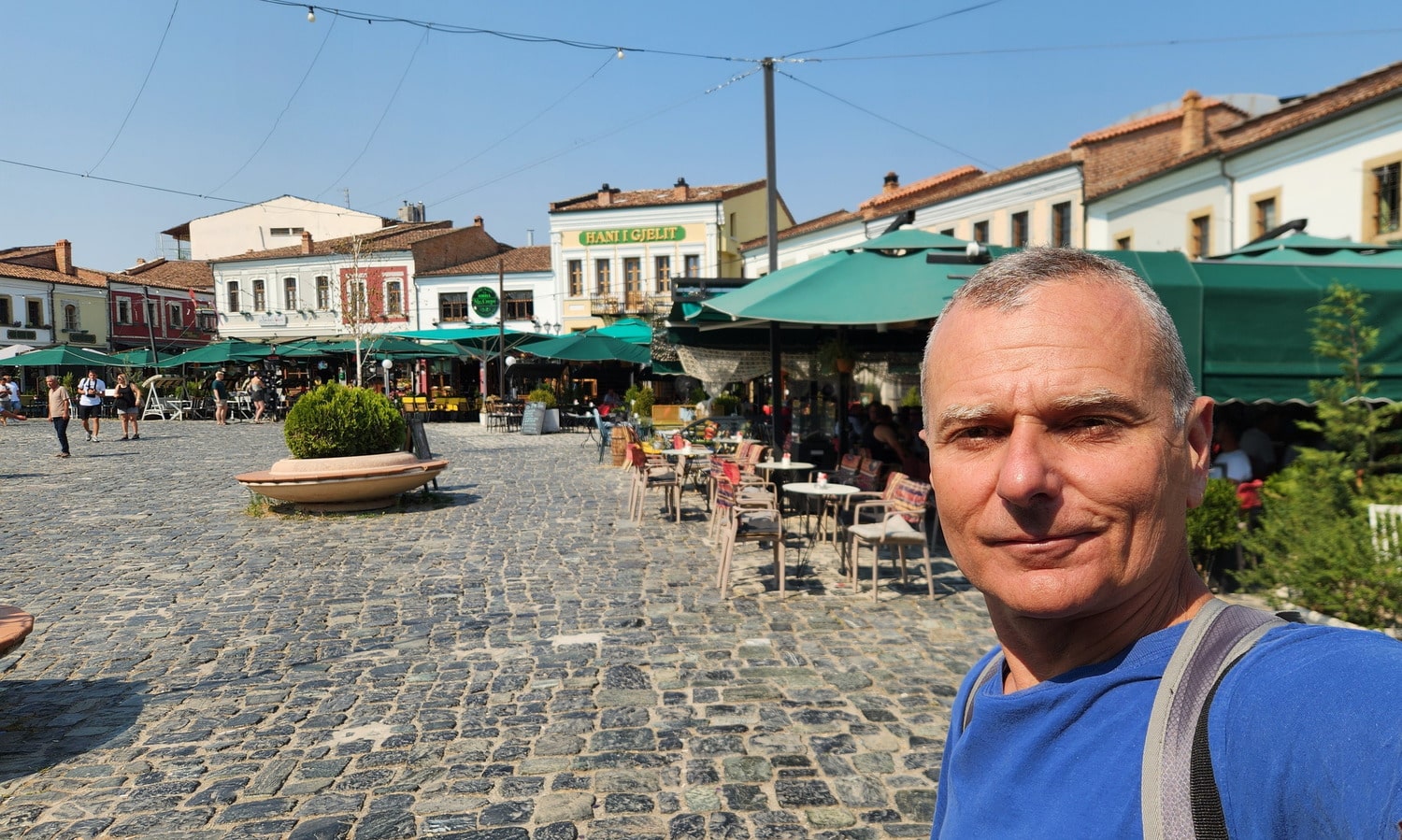 selfie on a plaza with many cafes and restaurants