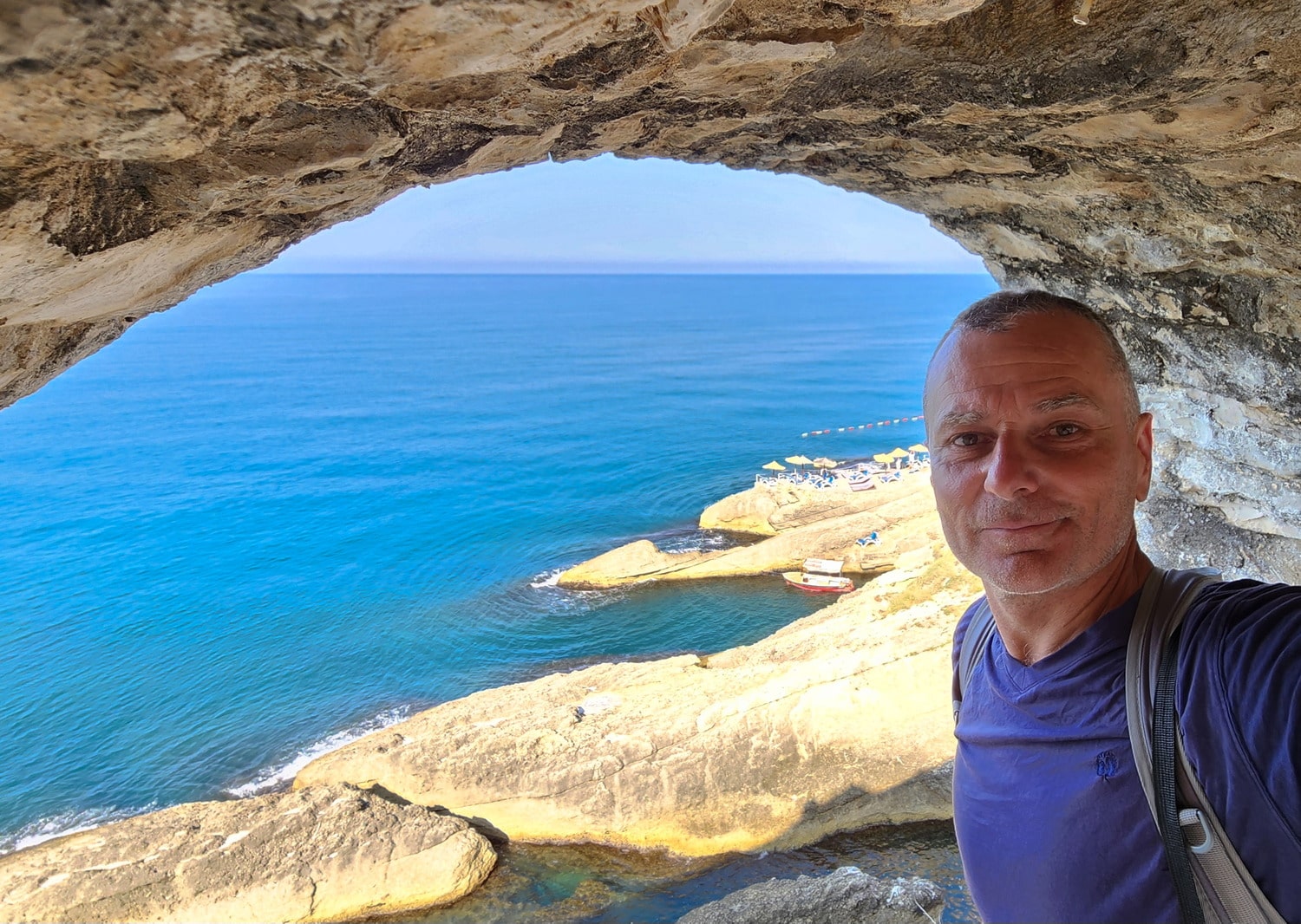 selfie near an opening in a stone wall looking over the sea