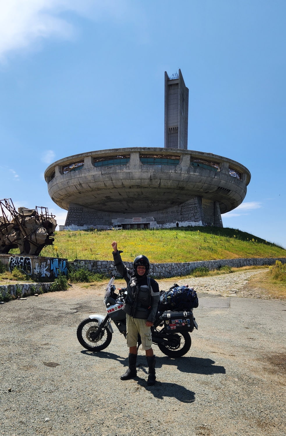 rider and motorcycle in front of a spaceship-looking building