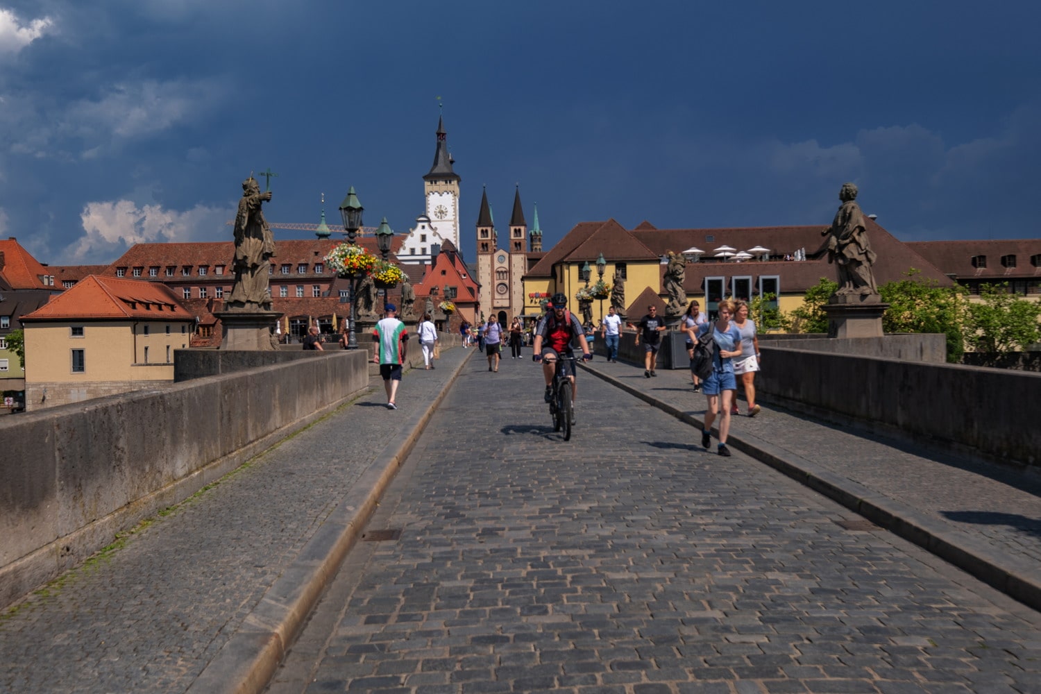 busy pedestrian bridge and church towers behind