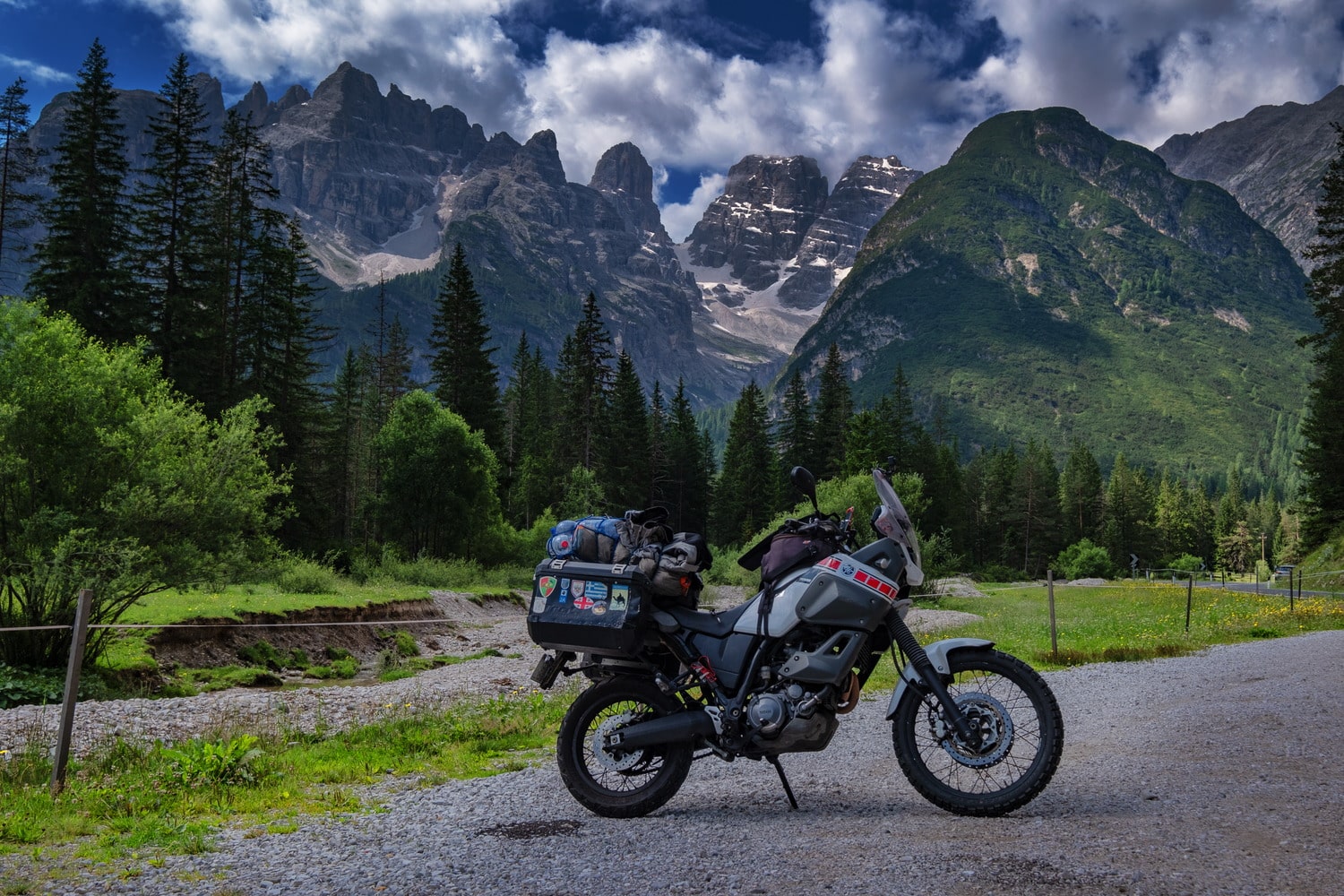 motorcycle parked with snowy mountains behind