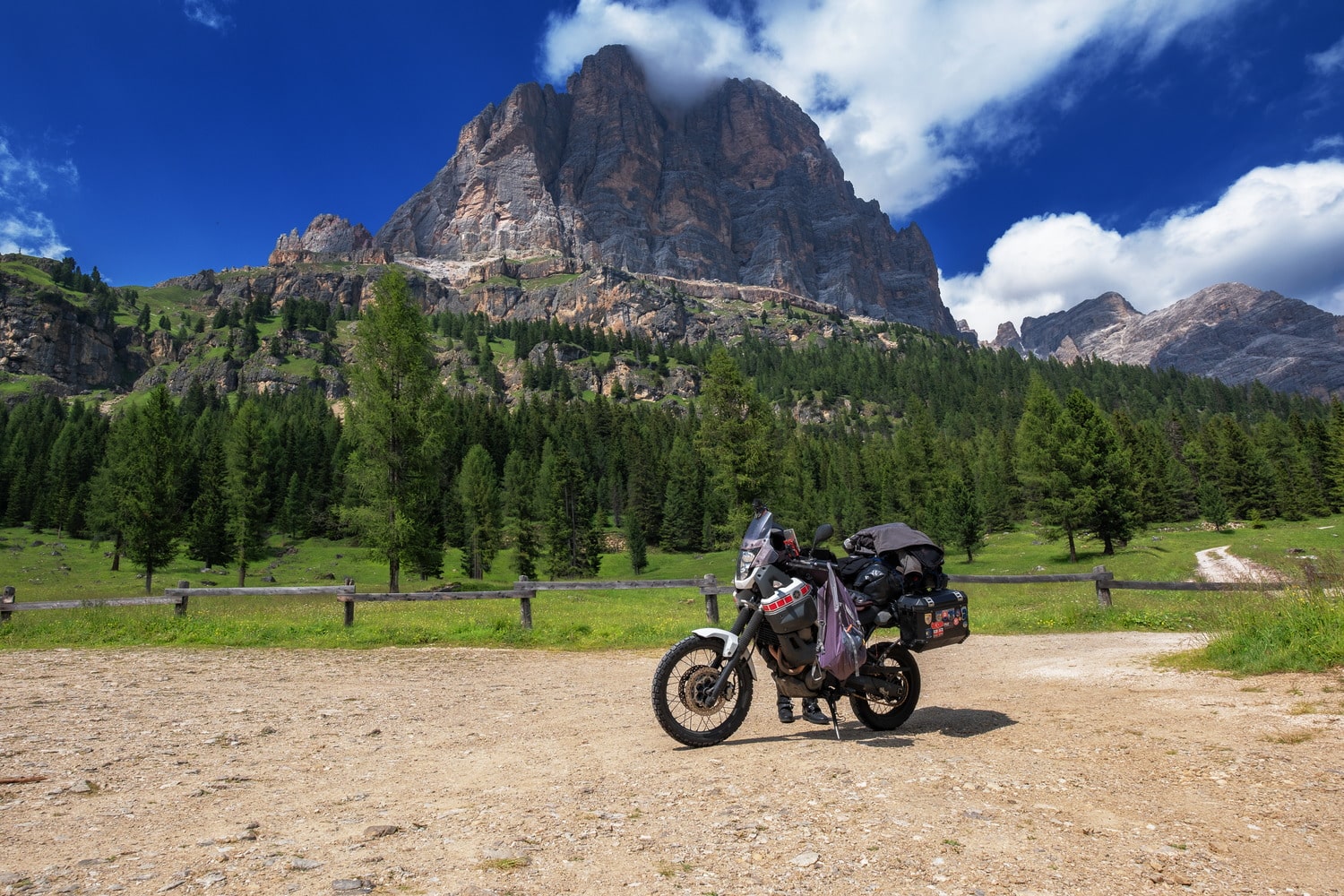 motorcycle parked with steep mountain behind