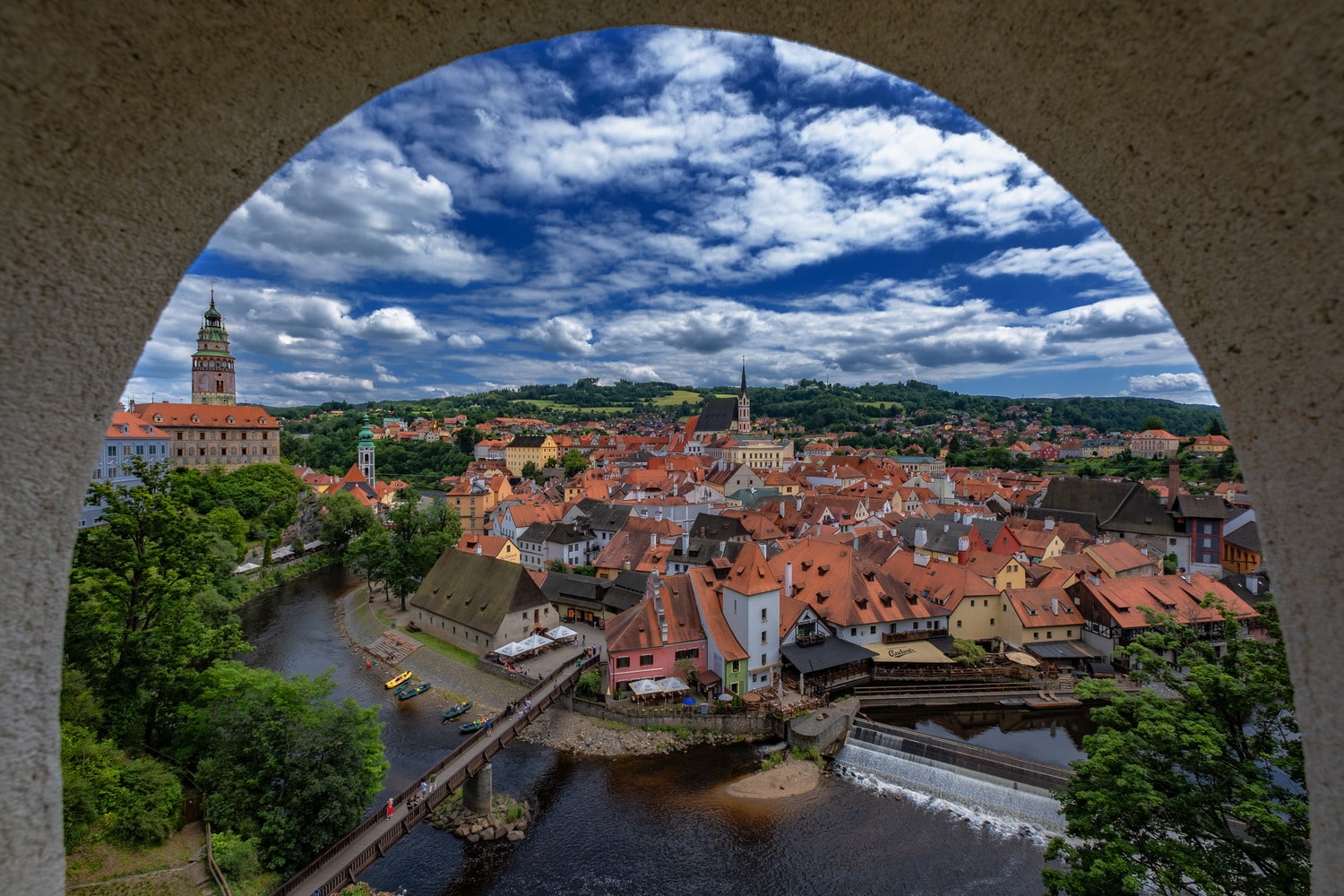 view of a town and river through an opening in a wall