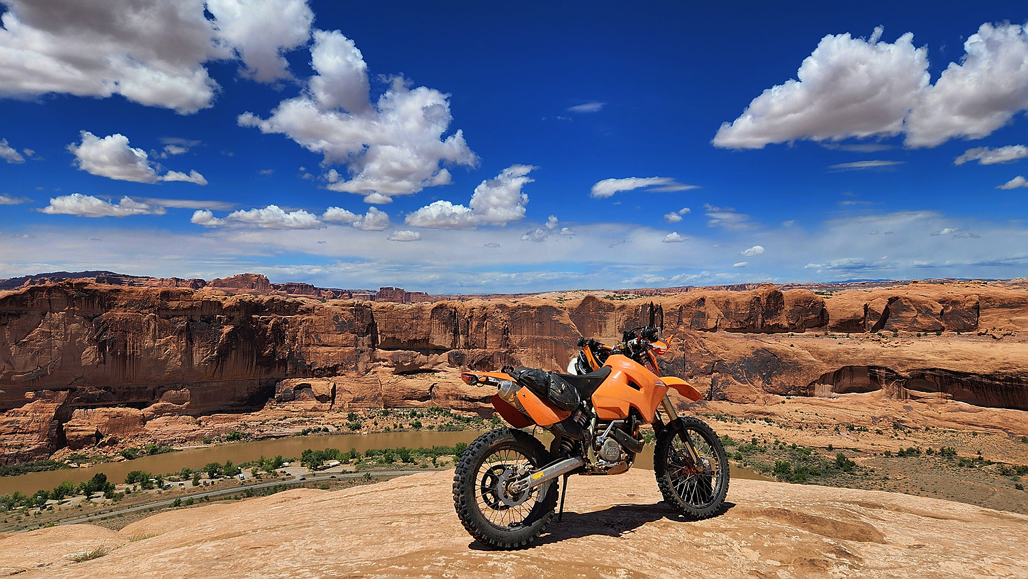 motorcycle parked high above a big river going through a canyon