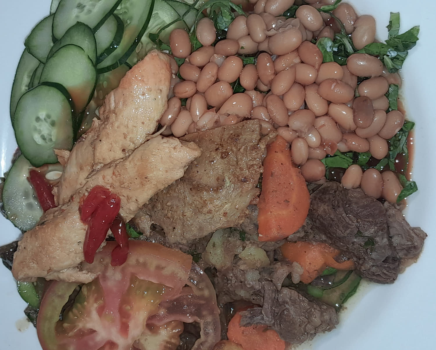 a plate loaded with meat, salad and veggies