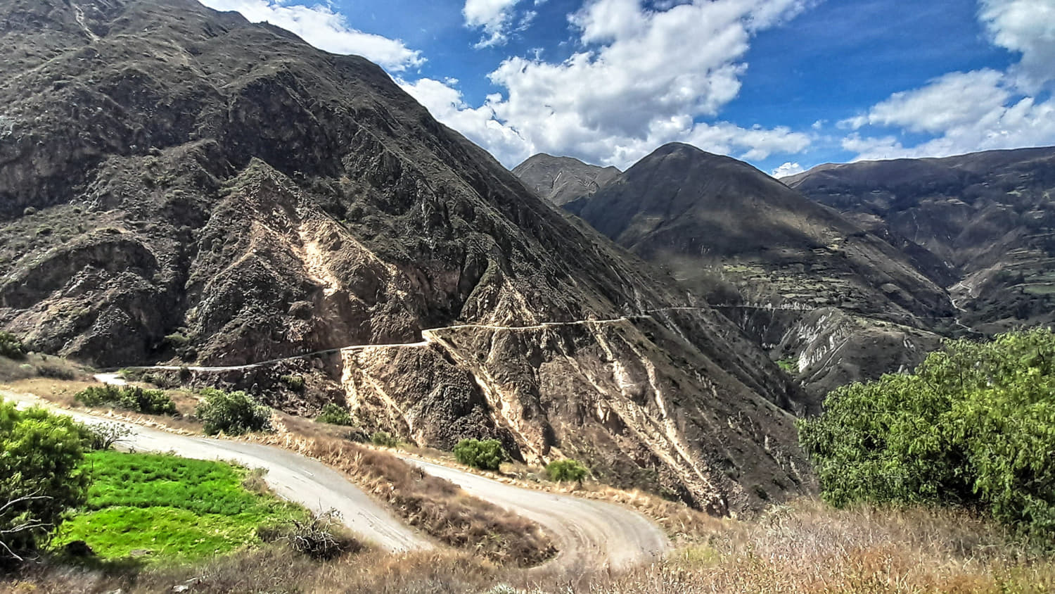 dirt road snaking its way around gullies and ridges of a steep
             mountain slope