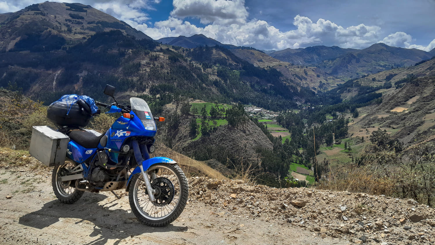 motorcycle parked with green mountains behind