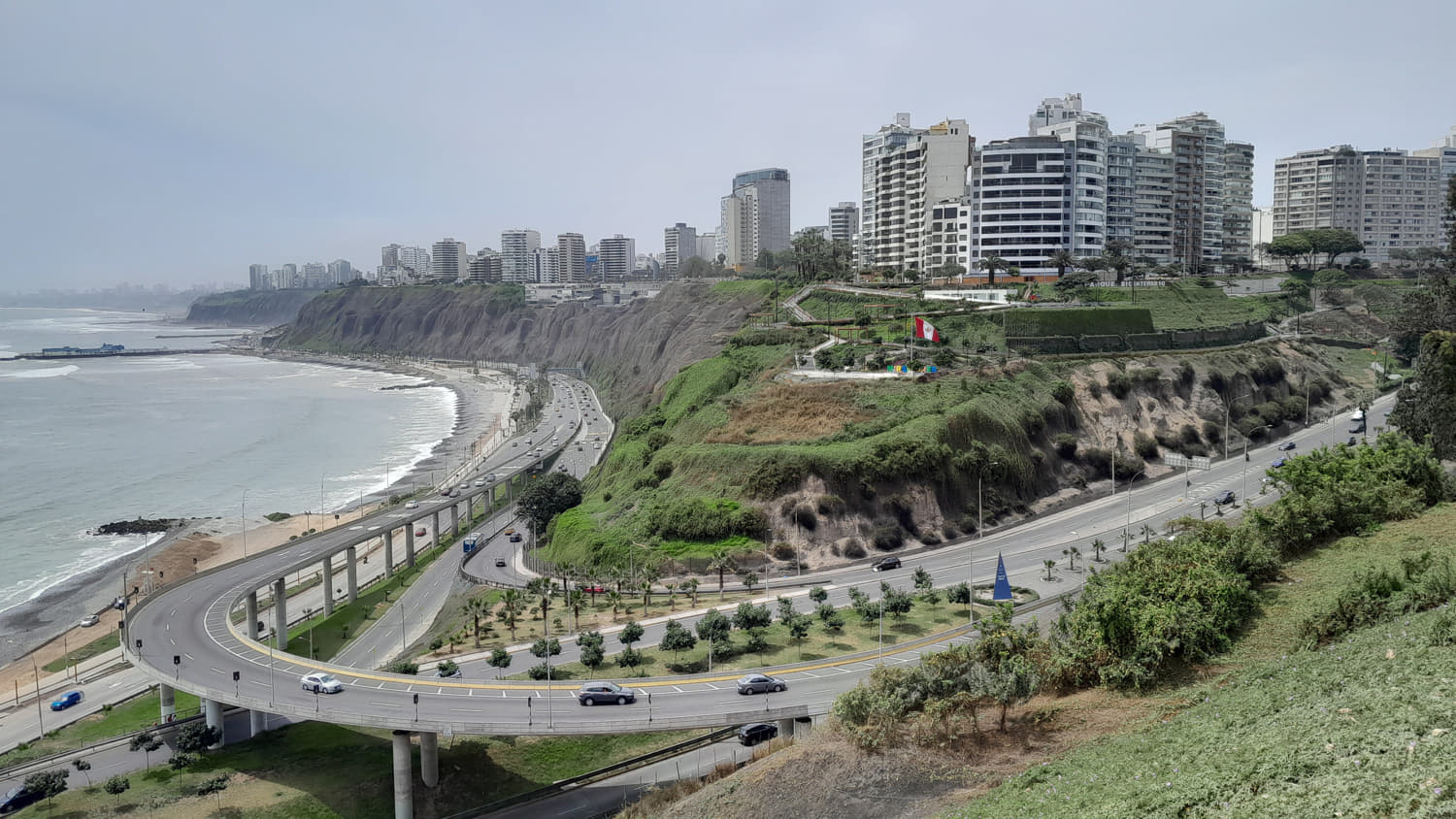 view of city hirises atop a cliff above the ocean