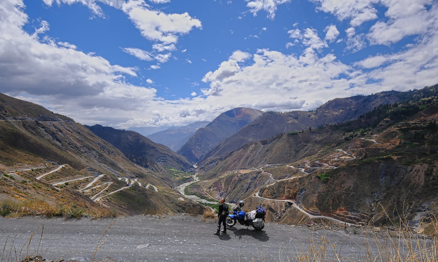 motorcycle and rider above a canyon and switchback on the two
             sides of the canyon