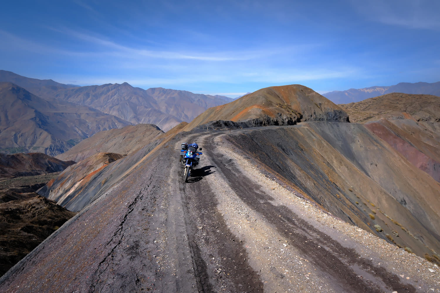 motorcycle parked ona dirt road along a ridge