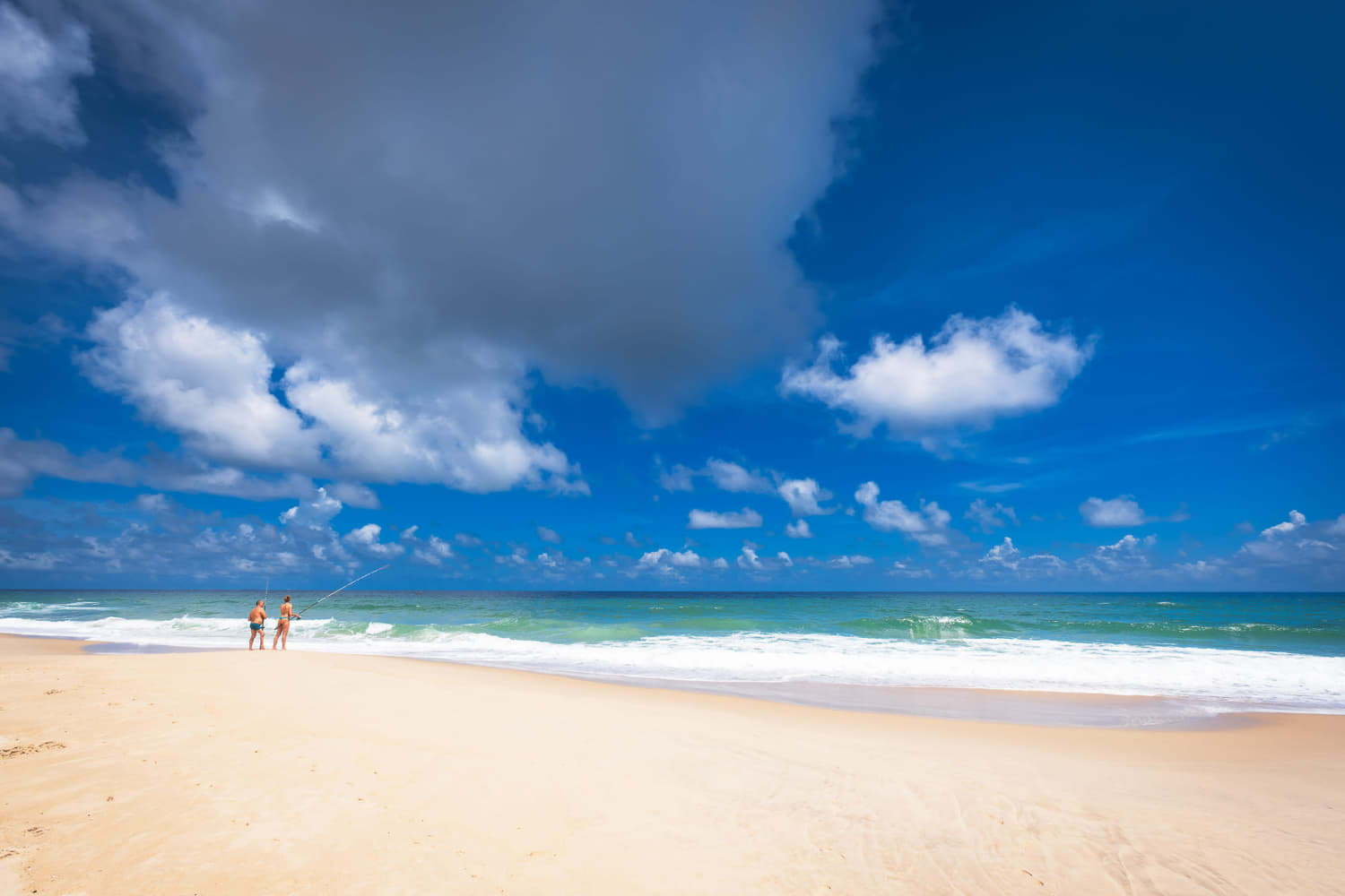 a couple sitting in beach chairs on a lonely beach