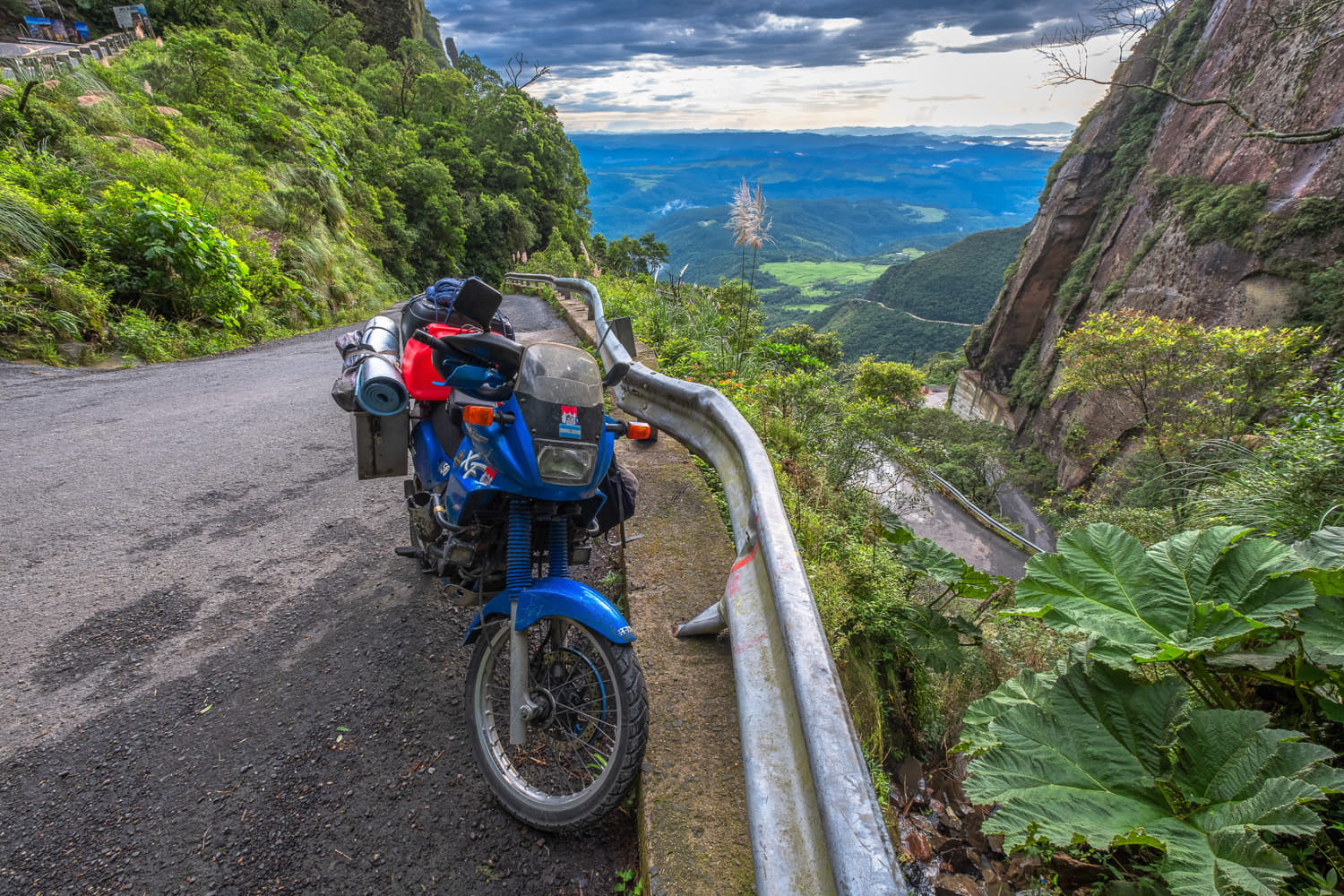 motorcycle parked on a steep road through a canyon