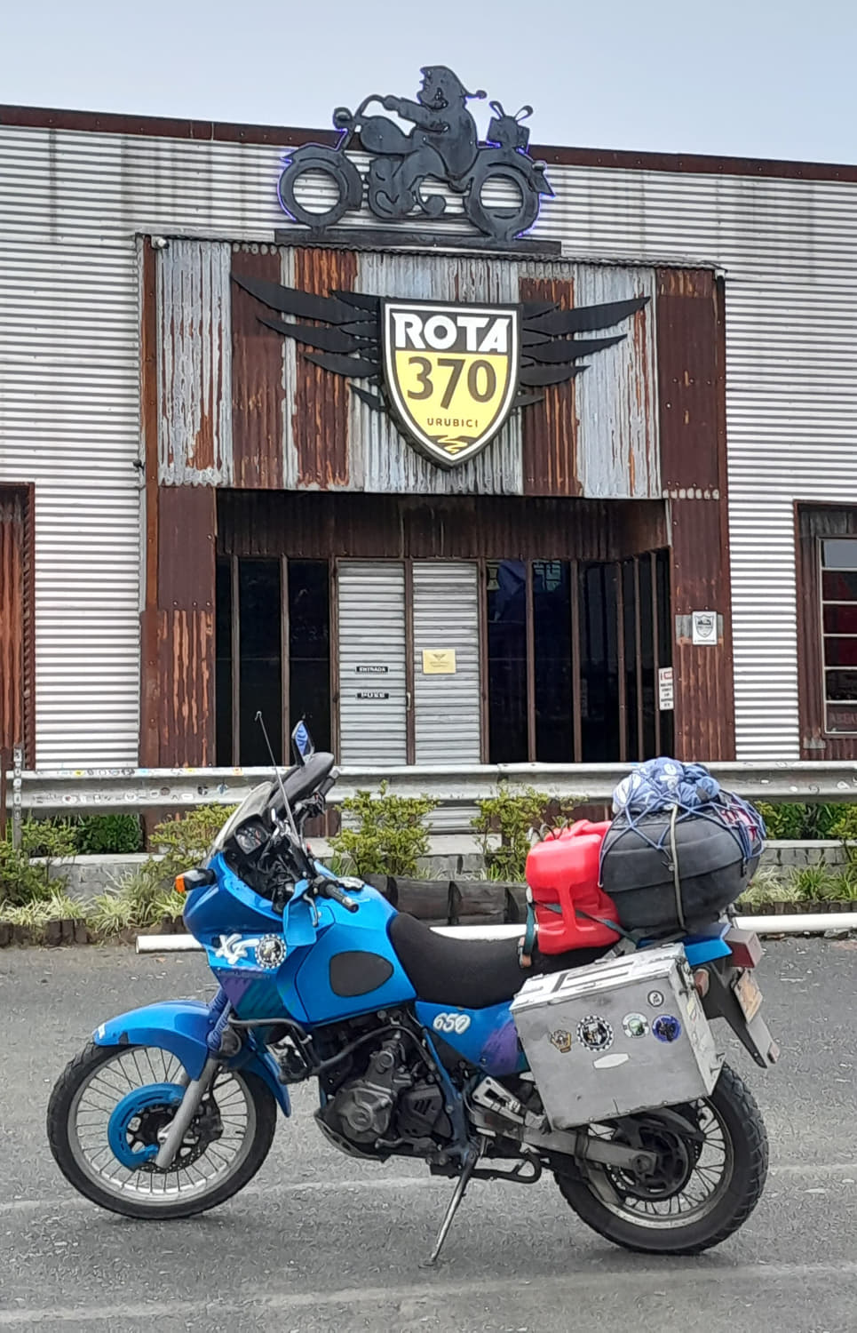 motorcycle parked in front of a building with big sign ruta 370