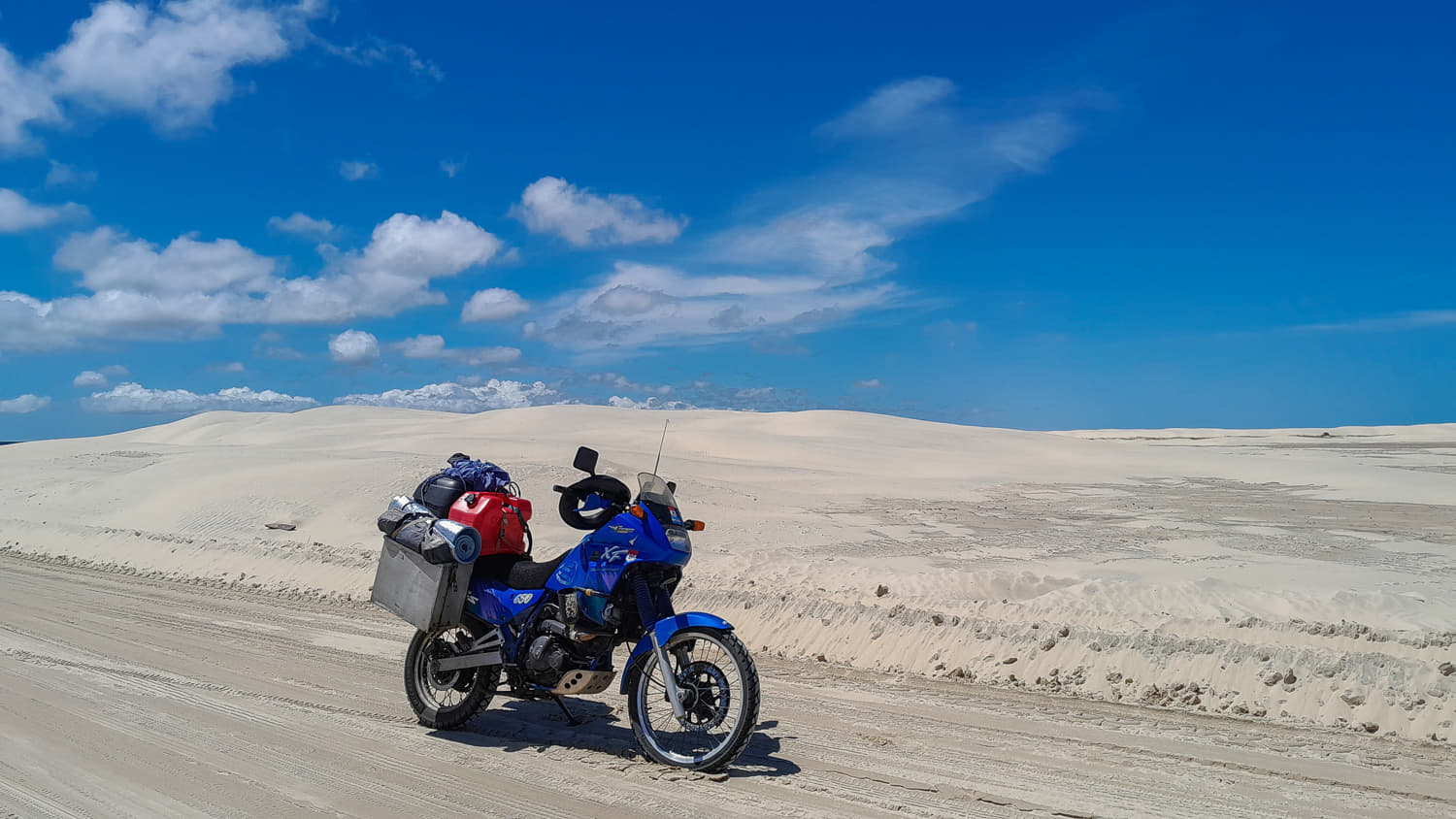 motorcycle parked with a small white sand dune behind