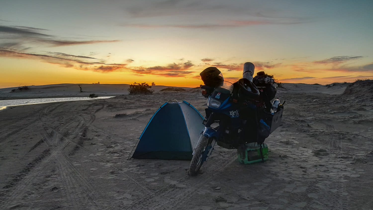  motorcycle parked next to a tent at twiglight