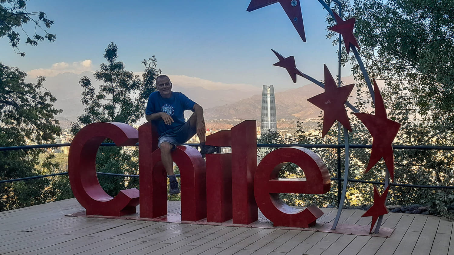 sitting on a sign Chile atop a hill