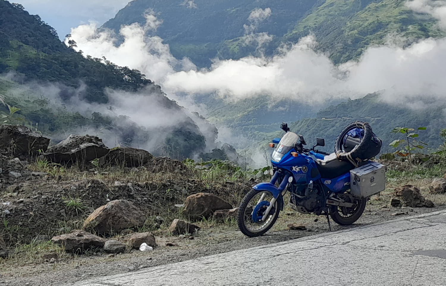 motorcycle parked on a bridge with water cascading behind