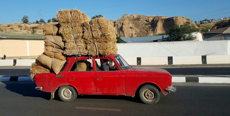 old soviet-era car overloaded with hay