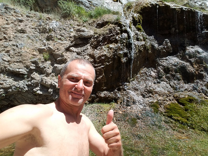 taking a selfie in front of a faint waterfall