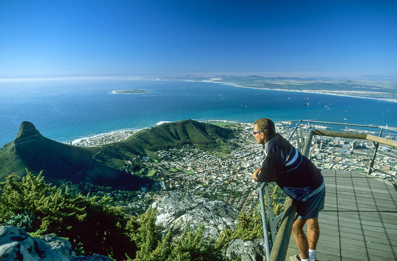 standing atop a cliff overlooking Cape Town and ocean beyond