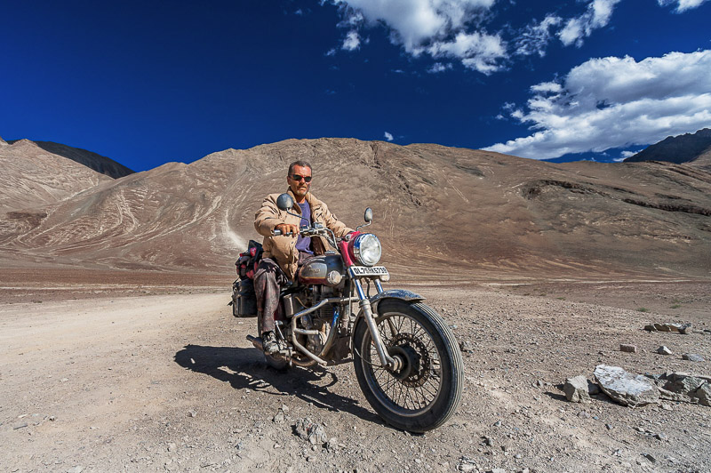 rider on a motorcycle with baren mountains behind