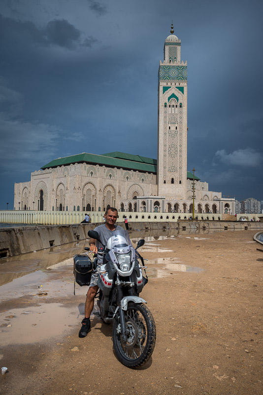 posing on a motorcycle in front of a mosque